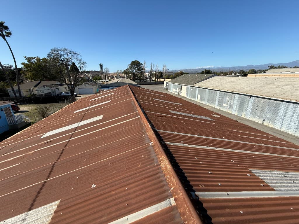 Heavily rusted corrugated metal industrial roof in Oxnard before replacement