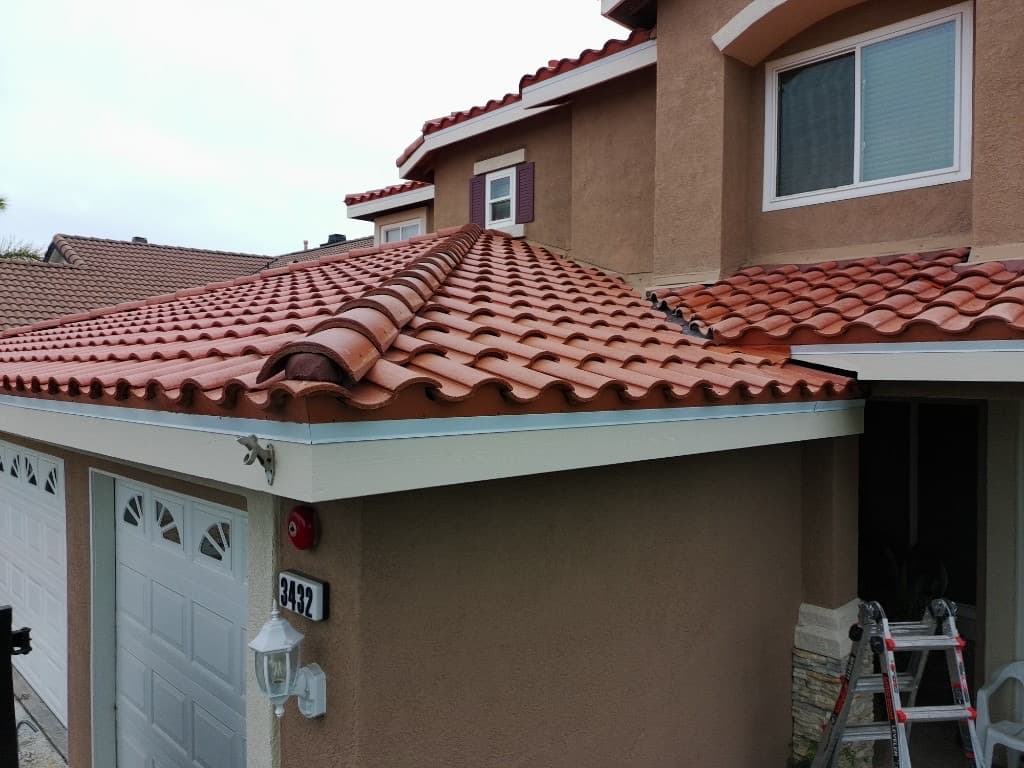 Close aerial view of gray tile roofing with ridge lines and vents