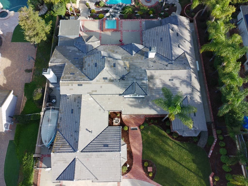 Aerial view of the same Simi Valley home after tile lift and reset with gray tile roof, chimneys, and landscaped yard