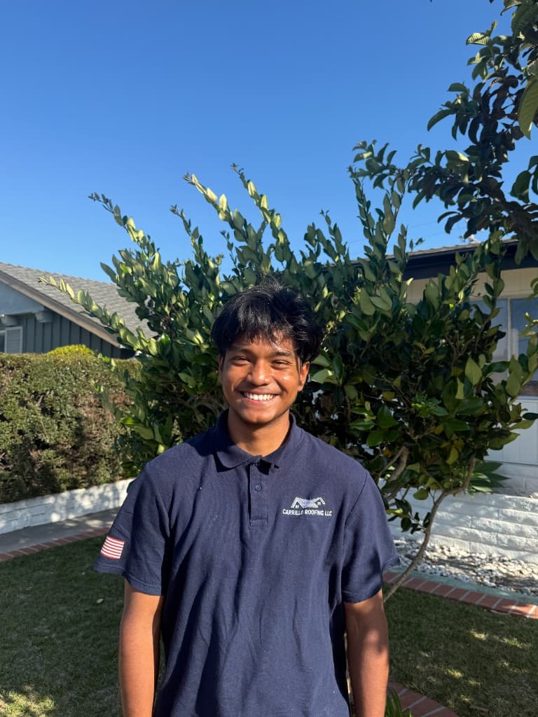 Angel David Carrillo, roofing consultant at Carrillo Roofing LLC, wearing company polo outdoors