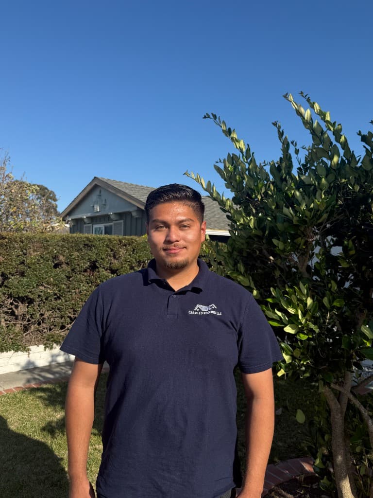 Anthony Carrillo, CEO of Carrillo Roofing LLC, wearing company polo outdoors