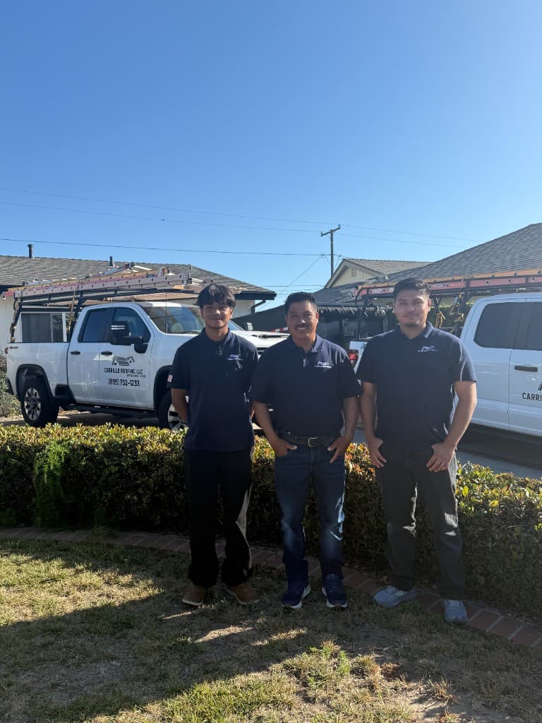Anthony, Margarito, and Angel David Carrillo of Carrillo Roofing LLC standing in front of company work trucks with ladders