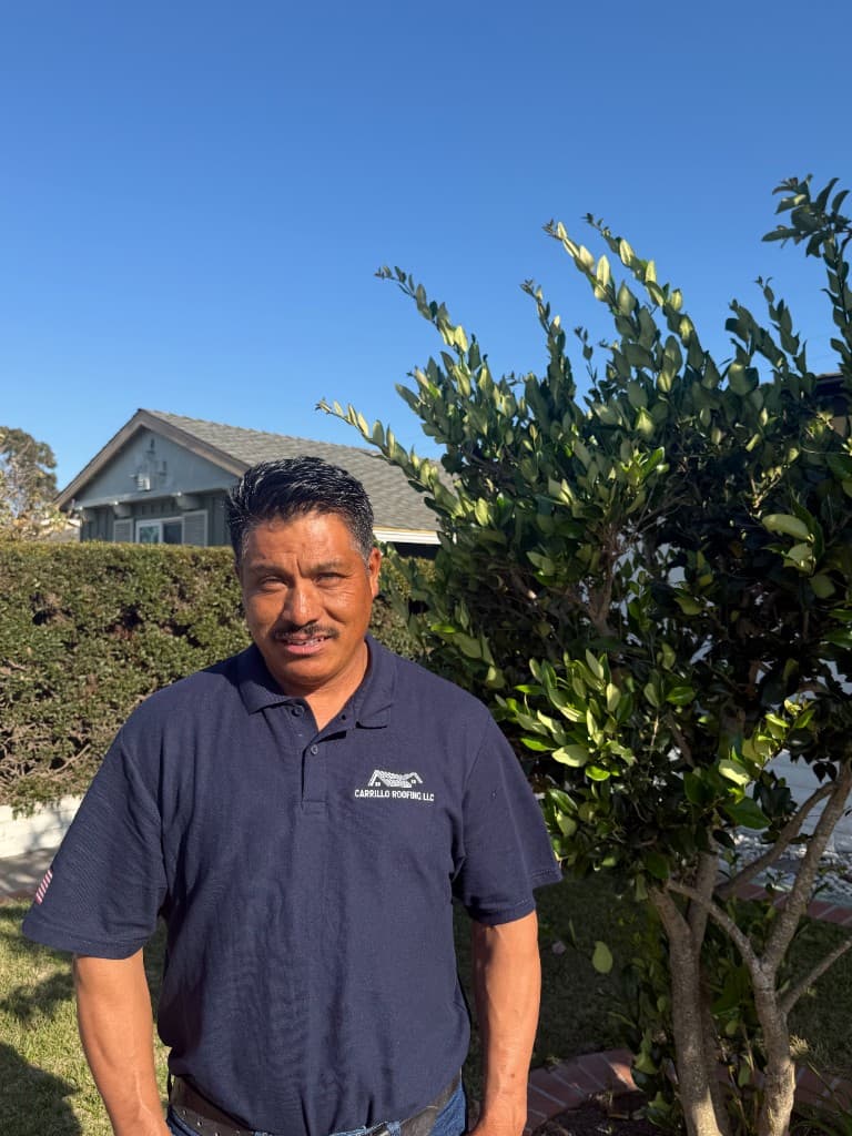 Margarito Carrillo, co-owner and project manager of Carrillo Roofing LLC, wearing company polo outdoors