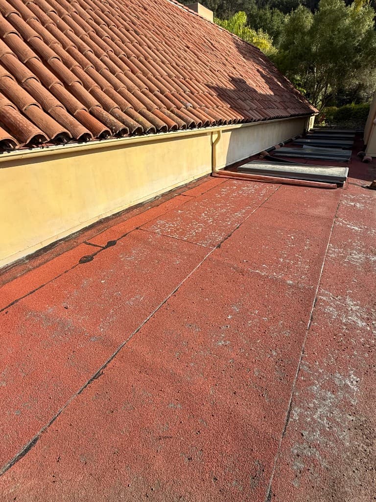 Worn flat roof at tile roof transition before Carrillo Roofing replacement