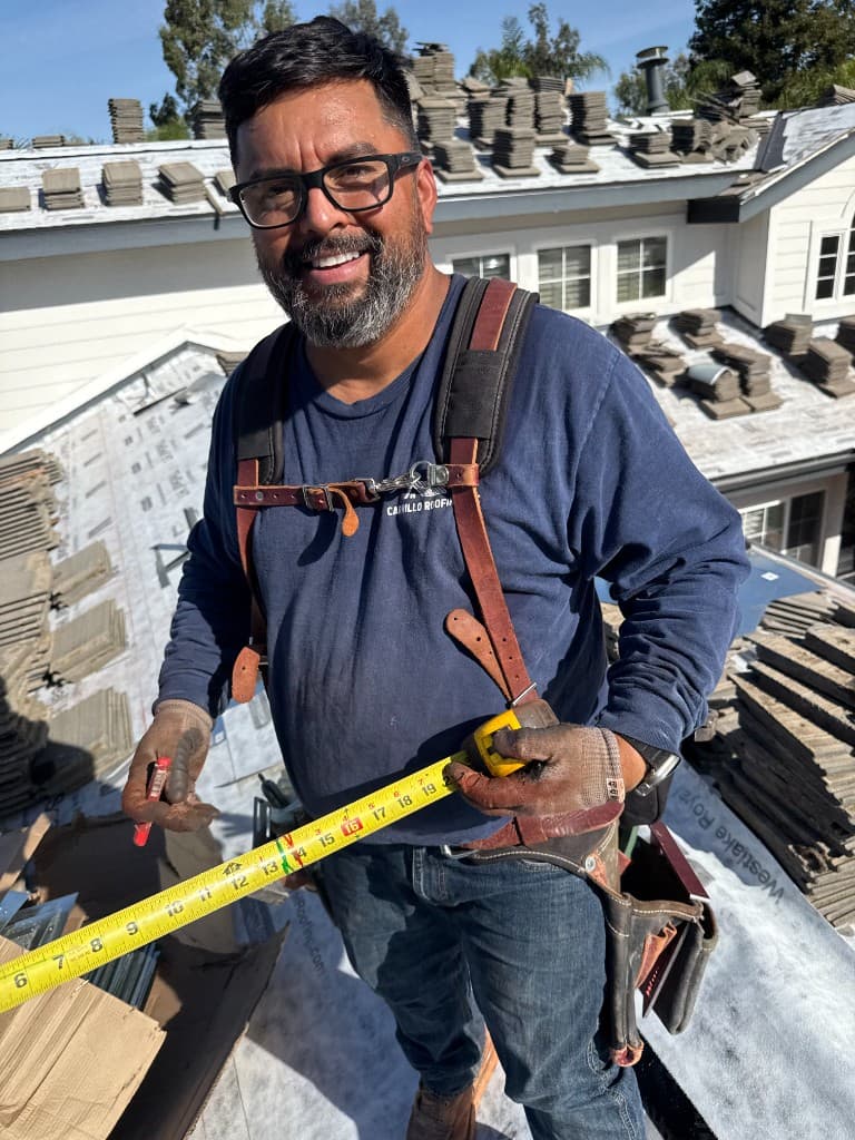 Margarito Carrillo, co-owner and project manager, measuring a residential tile roof during installation in Ventura County